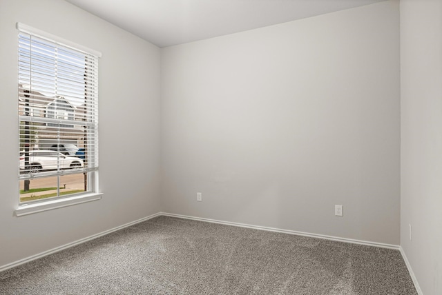 carpeted empty room with baseboards