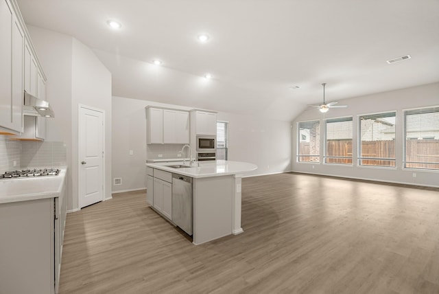 kitchen with light countertops, visible vents, appliances with stainless steel finishes, open floor plan, and a kitchen island with sink