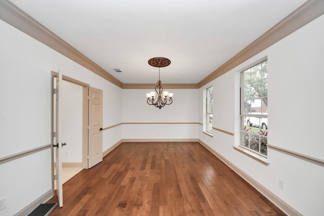 unfurnished dining area featuring dark hardwood / wood-style flooring, crown molding, a chandelier, and a healthy amount of sunlight