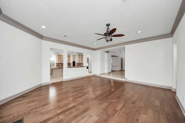 unfurnished living room with ceiling fan, wood-type flooring, and crown molding