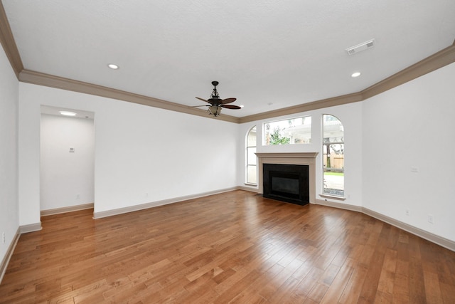 unfurnished living room with ceiling fan, ornamental molding, and light hardwood / wood-style flooring