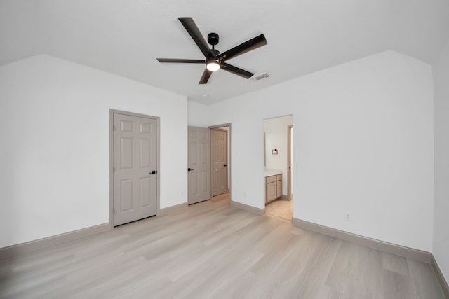 unfurnished bedroom with ceiling fan, ensuite bath, and light wood-type flooring