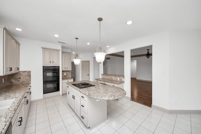 kitchen with a kitchen island, black appliances, decorative backsplash, a kitchen bar, and hanging light fixtures