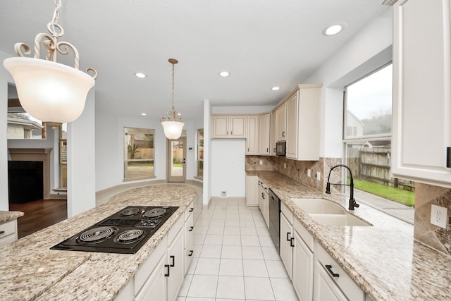 kitchen featuring black appliances, decorative light fixtures, decorative backsplash, sink, and light tile patterned flooring