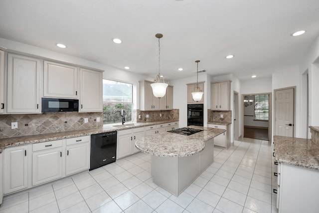 kitchen with black appliances, a center island, decorative light fixtures, sink, and backsplash