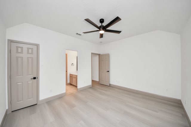 unfurnished bedroom featuring ceiling fan, vaulted ceiling, light hardwood / wood-style floors, ensuite bath, and a textured ceiling