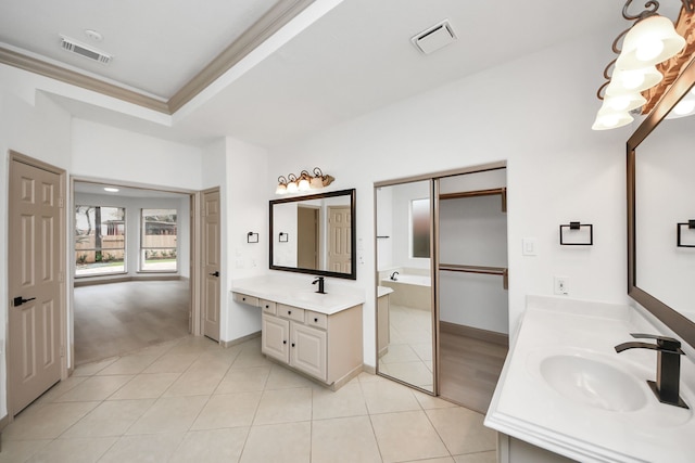 bathroom featuring a raised ceiling, tile patterned floors, ornamental molding, a washtub, and vanity