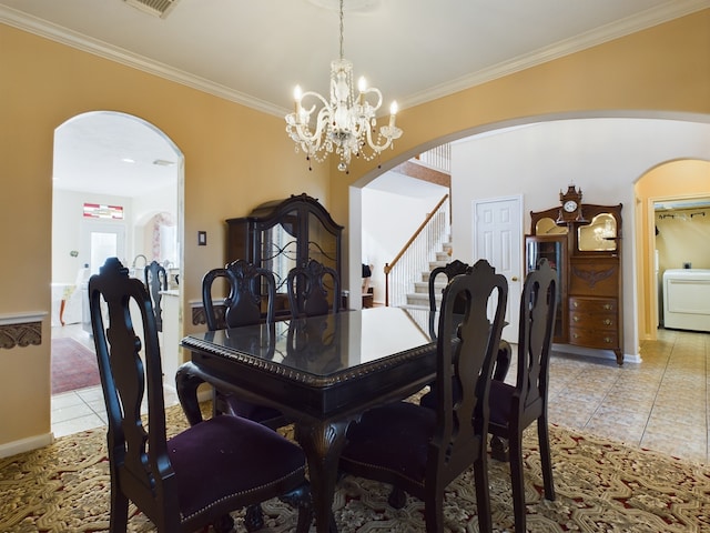 tiled dining space with crown molding, a chandelier, and washer / dryer