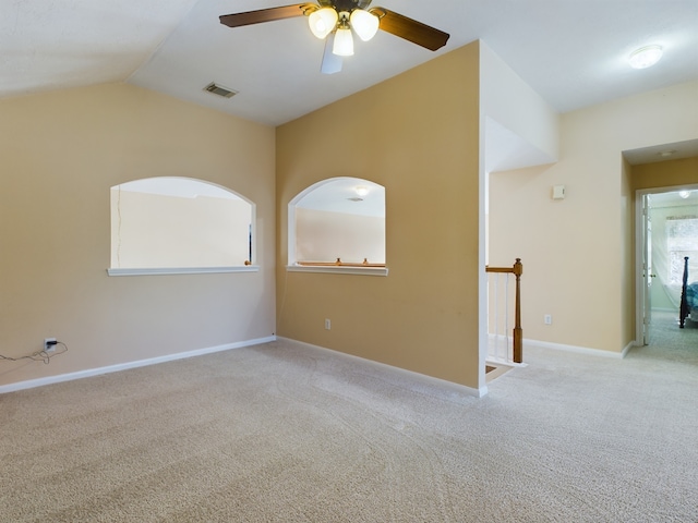 empty room featuring ceiling fan, light carpet, and lofted ceiling