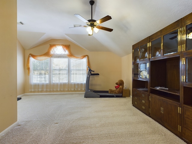 workout room with ceiling fan, light colored carpet, and lofted ceiling