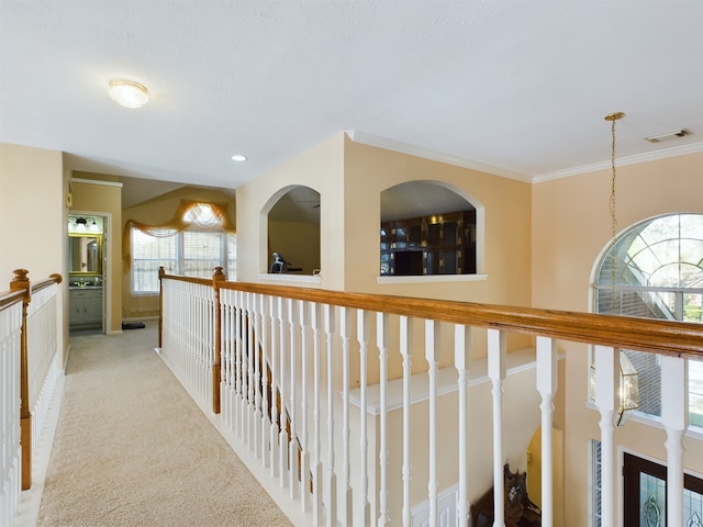 corridor featuring light colored carpet and crown molding