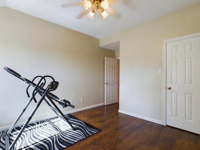 exercise area with ceiling fan and dark hardwood / wood-style flooring