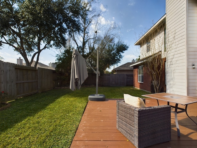 wooden terrace featuring a lawn