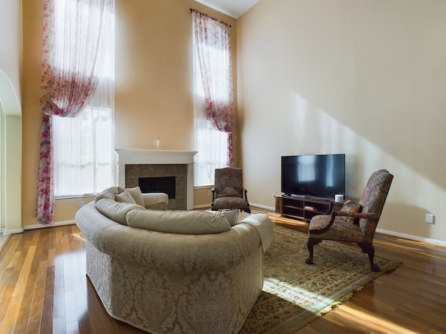 living room with hardwood / wood-style flooring, a tile fireplace, and plenty of natural light