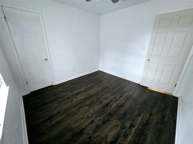 unfurnished bedroom with dark wood-style flooring, ceiling fan, and baseboards