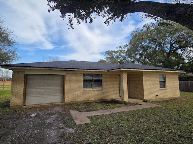 single story home with a garage, brick siding, and a front lawn