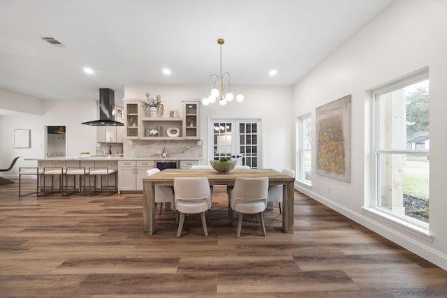 dining room with dark wood-type flooring, a wealth of natural light, and french doors