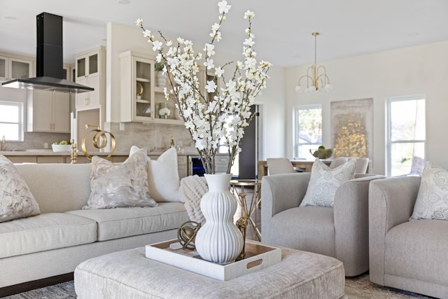 living room featuring an inviting chandelier, a wealth of natural light, and sink