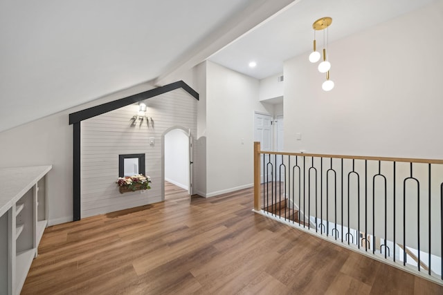 interior space with lofted ceiling with beams and hardwood / wood-style flooring