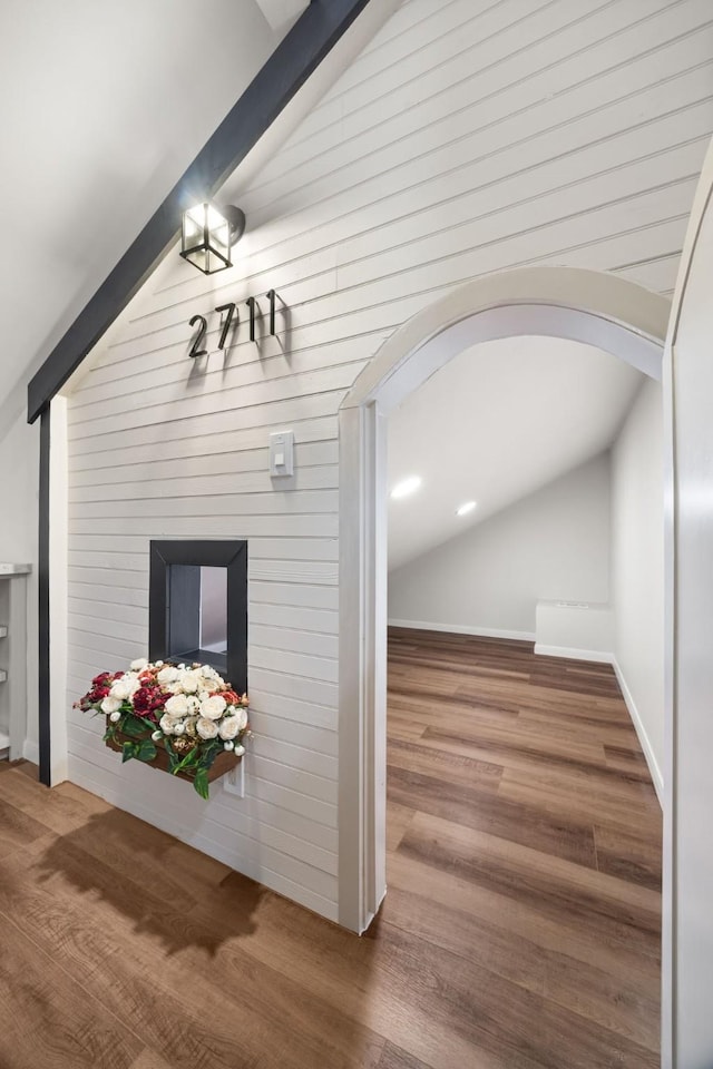 interior space with hardwood / wood-style flooring and lofted ceiling with beams