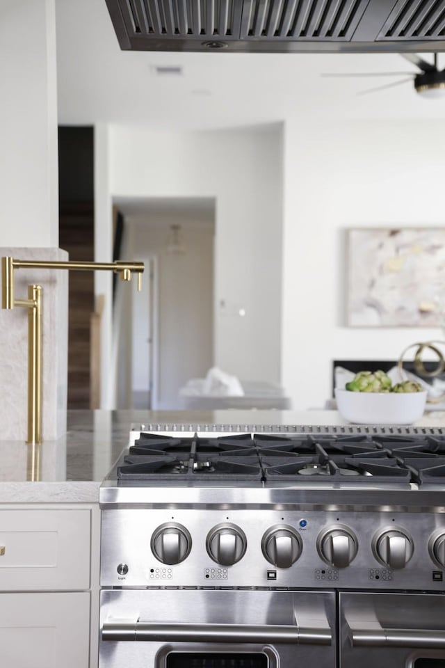 kitchen featuring white cabinetry and high end range