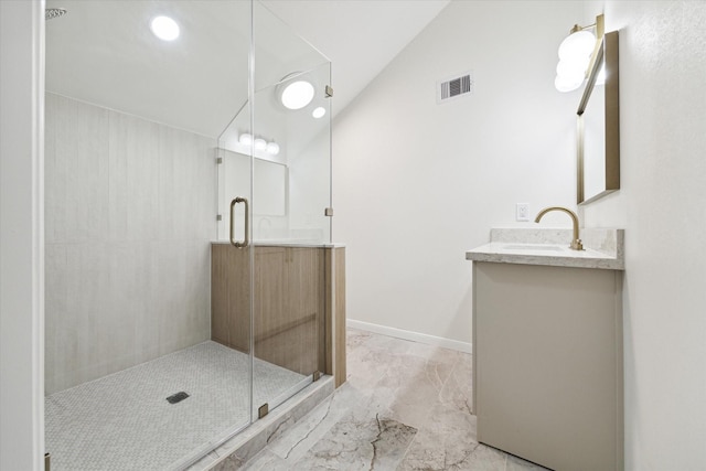 bathroom featuring a shower with shower door, vanity, and vaulted ceiling