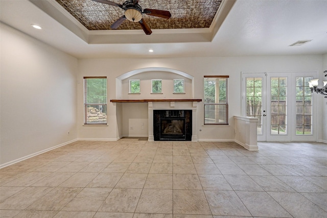 unfurnished living room featuring ceiling fan, ornamental molding, a fireplace, and a tray ceiling