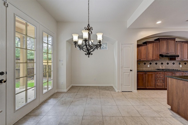 kitchen with tasteful backsplash, a notable chandelier, light tile patterned flooring, and pendant lighting