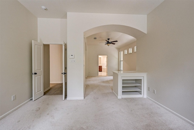 carpeted spare room with ceiling fan and built in features