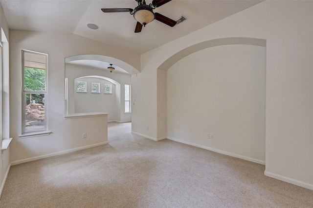 unfurnished room featuring ceiling fan, light colored carpet, and vaulted ceiling