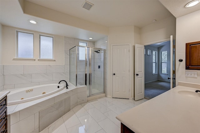 bathroom featuring vanity and independent shower and bath