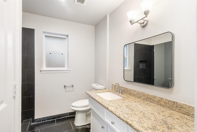 bathroom featuring toilet, tile patterned flooring, and vanity