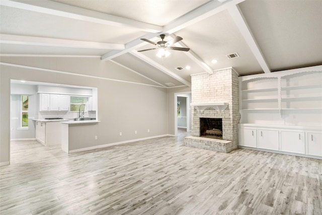 unfurnished living room featuring ceiling fan, built in features, a fireplace, and light hardwood / wood-style flooring