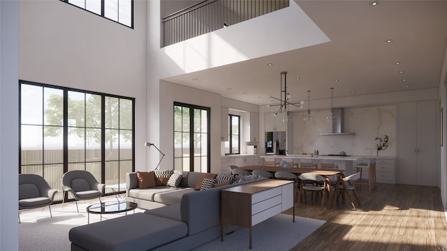 living room featuring an inviting chandelier, light hardwood / wood-style flooring, and a high ceiling