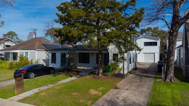 view of front of home featuring a front yard, a garage, and solar panels