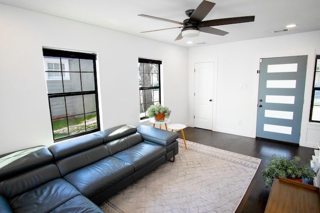 living room featuring ceiling fan and dark hardwood / wood-style floors