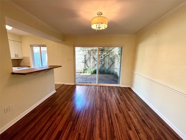 unfurnished dining area with dark wood-type flooring and ornamental molding