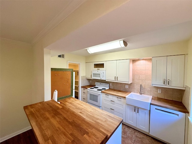 kitchen featuring butcher block counters, sink, backsplash, white cabinets, and white appliances