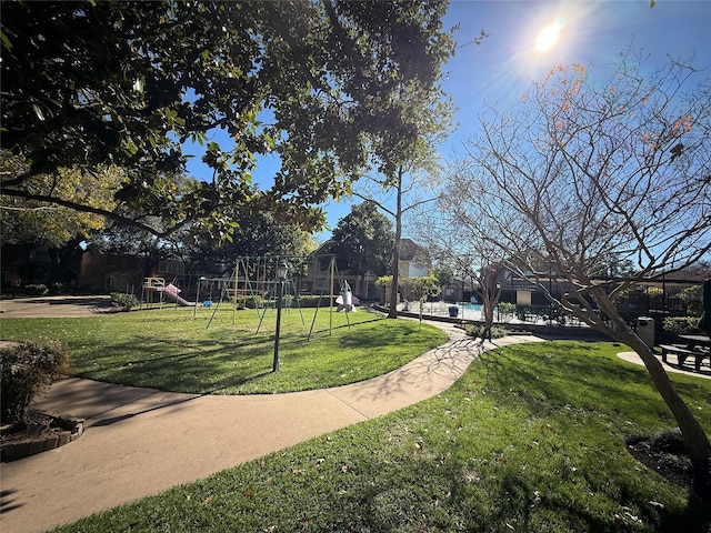 view of home's community with a playground and a lawn