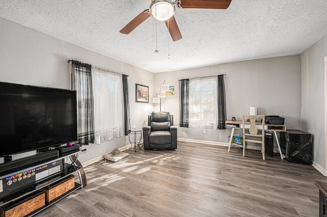 living area with a healthy amount of sunlight, hardwood / wood-style floors, and a textured ceiling