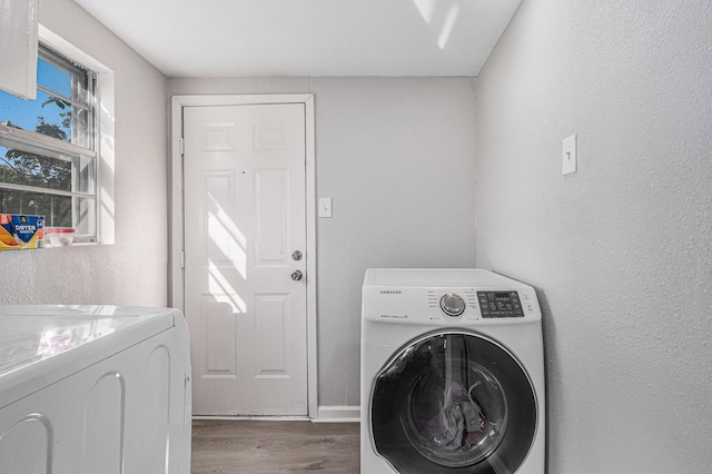 laundry room with wood-type flooring and washing machine and dryer