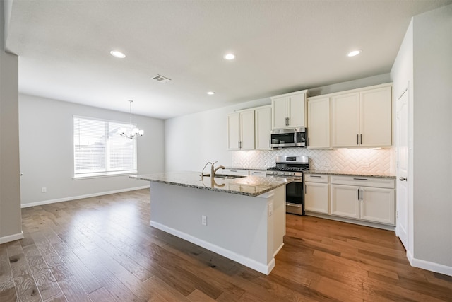 kitchen featuring stainless steel appliances, sink, a center island with sink, and white cabinets