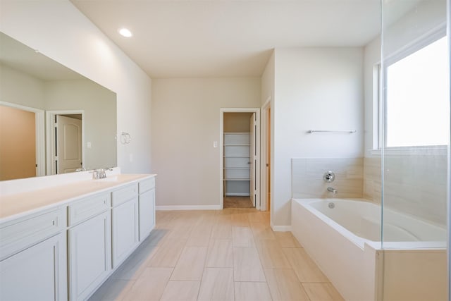 bathroom featuring a tub to relax in and vanity