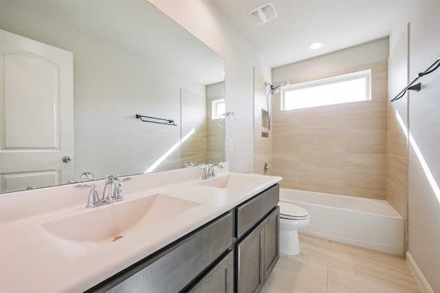 full bathroom featuring vanity, toilet, tiled shower / bath combo, and tile patterned flooring