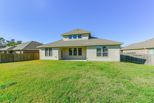 back of house featuring a lawn and a patio