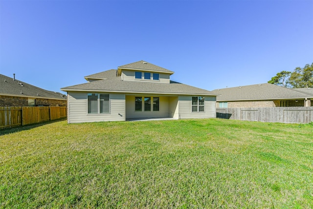 rear view of property featuring a lawn