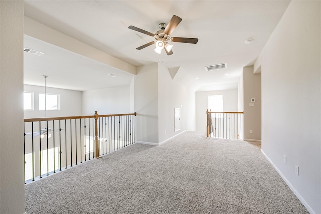 empty room featuring ceiling fan and carpet