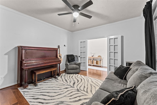 living room featuring hardwood / wood-style floors, ceiling fan, french doors, a textured ceiling, and ornamental molding