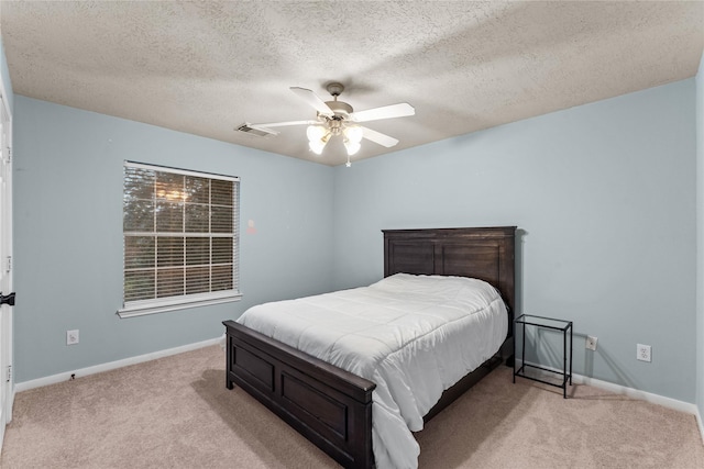 bedroom featuring a textured ceiling, ceiling fan, and light colored carpet