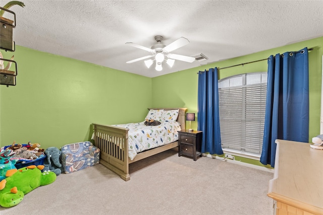 bedroom featuring ceiling fan, a textured ceiling, and carpet floors